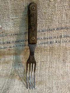 a fork that is laying on top of a table cloth with some sort of thing attached to it