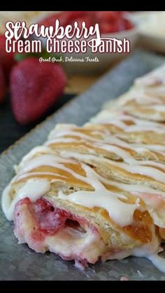 strawberry cream cheese danish on a baking sheet with strawberries in the background and text overlay