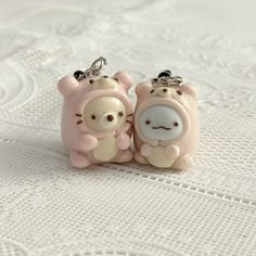 two little pig key chains sitting on top of a table