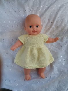 a baby doll is wearing a yellow dress