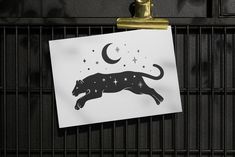 a black and white drawing of a cat on a piece of paper with stars in the sky