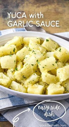 yuca with garlic sauce in a white bowl on top of a blue and white towel