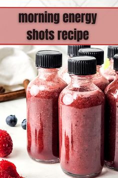 three jars filled with raspberry smoothie next to berries