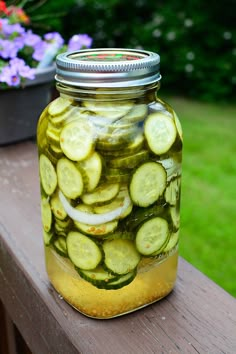 a jar filled with pickles sitting on top of a wooden table