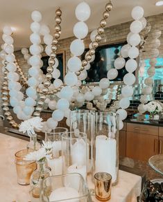 a table with candles, vases and balloons on it