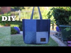 a blue and gray bag sitting on top of a grass covered field next to potted plants