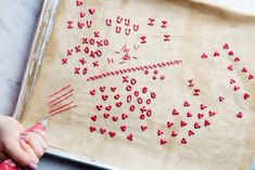 someone is making valentine's day hearts out of dough on a sheet of parchment paper