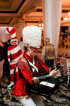 a woman dressed in red and white is holding a cell phone