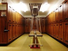 an empty room with wooden lockers and ladder on the floor in front of them