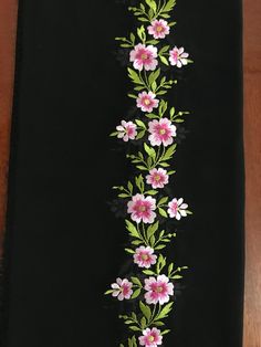 a black towel with pink and white flowers on it