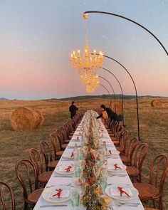 the long table is set with plates and place settings for people to sit at it