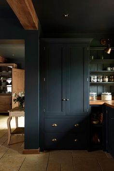 a kitchen with dark blue cabinets and wooden counter tops, along with an island in the middle