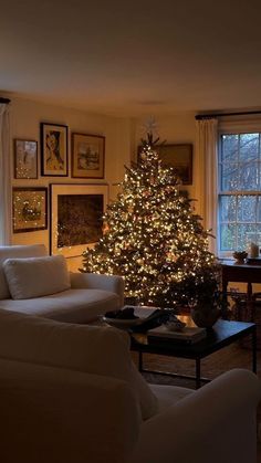 a living room filled with furniture and a lit christmas tree in the middle of it