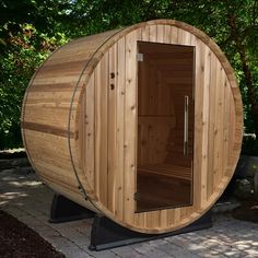 a wooden barrel sauna sitting on top of a brick walkway