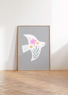 a white bird with pink flowers on it's body is flying in the air