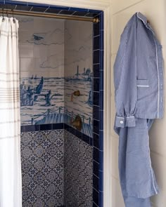 a blue and white tiled bathroom with an open shower door