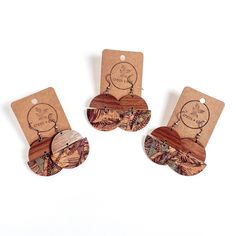 three wooden tags with different designs on them