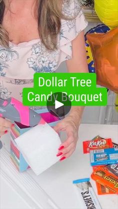 a woman is holding a dollar tree candy bar in front of her and some other items on the table