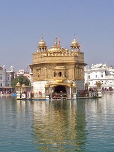 an ornate golden building sitting on top of a body of water