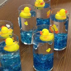 several glasses filled with water and rubber ducks