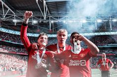 two soccer players are holding up their trophies in front of the crowd at a stadium