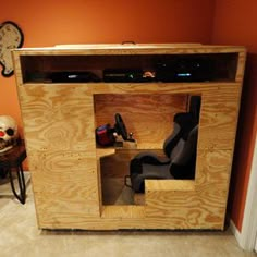 a room with a chair and a tv in it that is made out of plywood