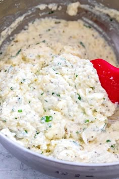 a red spatula in a mixing bowl filled with food