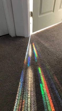 the light is shining on the floor in front of an open door, and it's shadows are cast onto the carpet