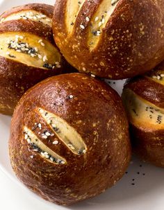 four round breads on a white plate with sprinkles and sesame seeds