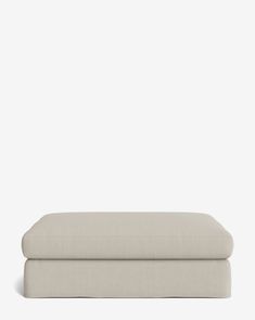 a white ottoman sitting on top of a floor