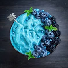 a blue dessert topped with berries and mint