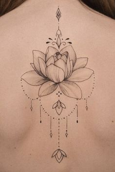 a woman's back with a lotus tattoo on her upper and lower back tattoos