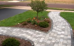 a brick walkway in the middle of a grassy area