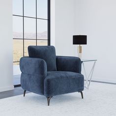 a blue chair sitting in front of a window next to a table with a lamp on it