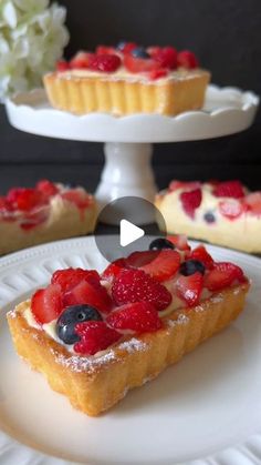 a piece of cake on a plate with berries and powdered sugar in the middle