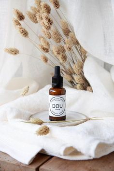 a bottle of dou sitting on top of a wooden table next to some dry grass