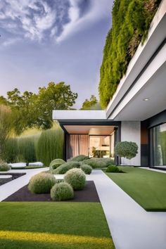 a modern house with grass and bushes in the front yard