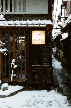 a small building covered in snow next to a street