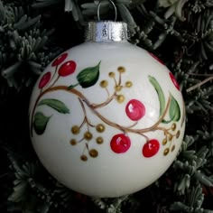 a white ornament with red berries and green leaves