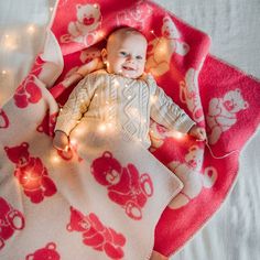 a baby is laying on a blanket with lights