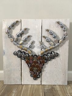 a deer head made out of buttons and other items on a wooden paneled wall