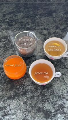 three cups filled with tea sitting on top of a counter