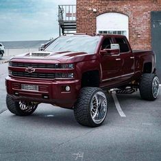 a red truck parked in front of a brick building