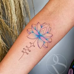 a woman's arm with a tattoo that has a blue flower on the center