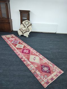 a rug is laying on the floor in front of a chair and bookcases