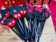 some black and red mickey mouse straws on a table with minnie mouse stick toppers