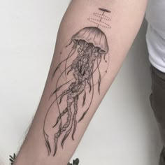 a black and white photo of a jellyfish tattoo on the arm