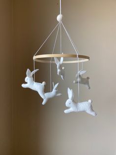 three white deer mobiles hanging from a ceiling