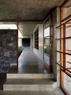 an empty hallway with stone walls and windows