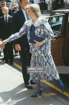 the princess of wales shaking hands with an official man